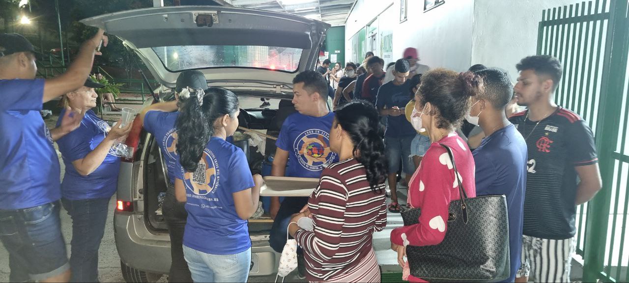 Voluntários distribuindo alimento durante ação noturna